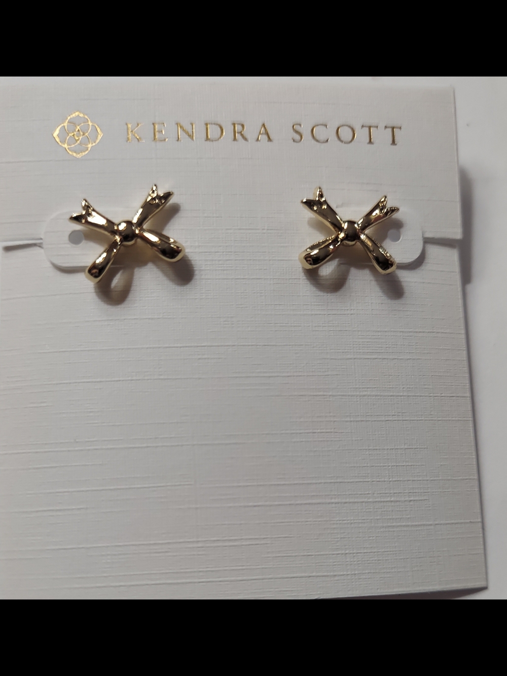 Kendra Scott stud earrings feature a polished gold-tone bow design.